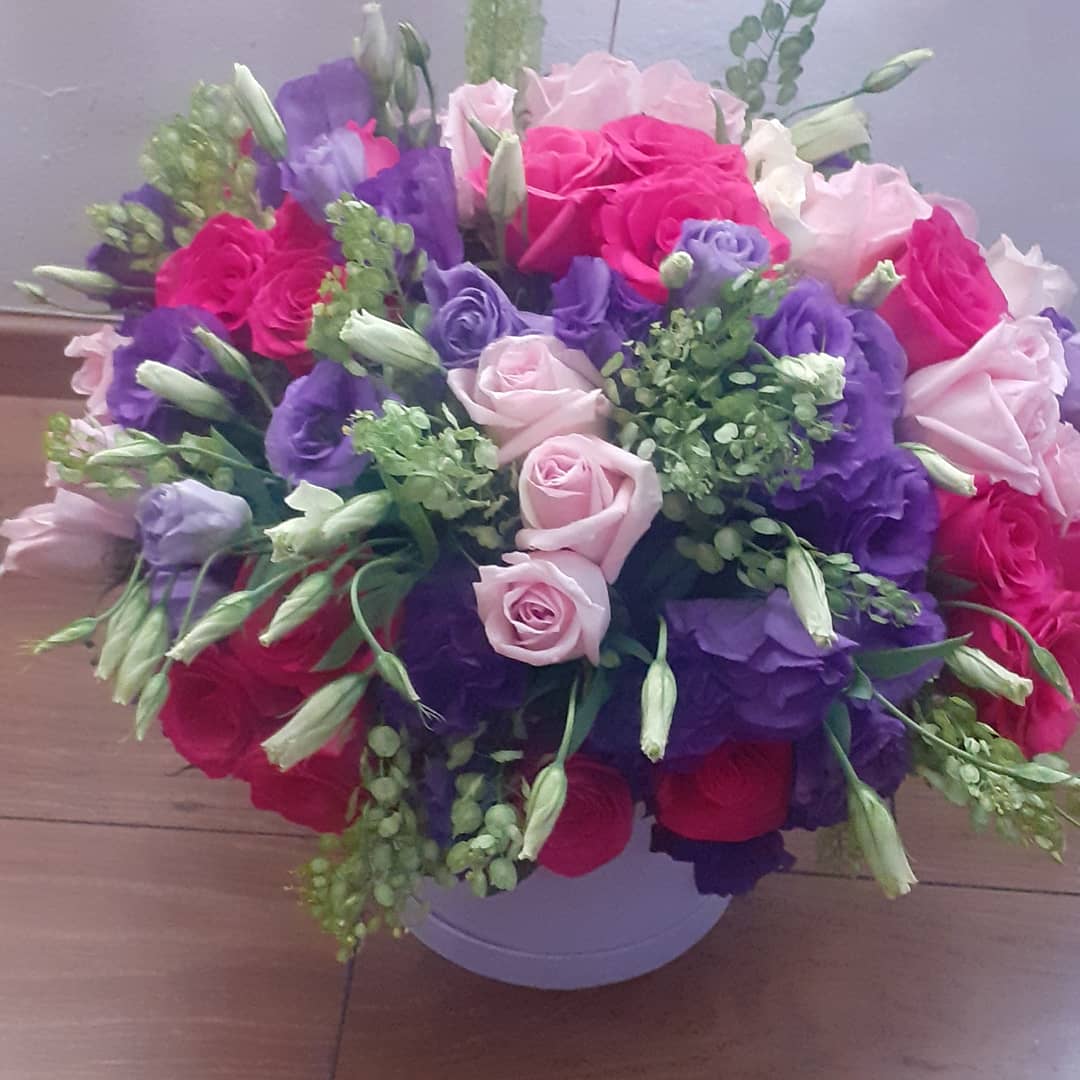 Caja con liciantus, rosas y follaje fino en tamaño grande